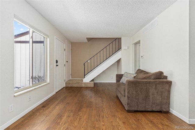 living room featuring wood-type flooring and a textured ceiling