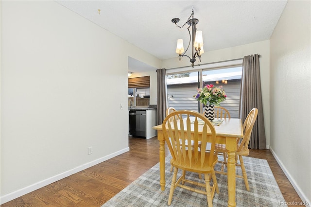 dining space with hardwood / wood-style floors and a chandelier