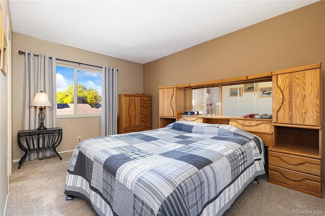 bedroom with light carpet and a textured ceiling