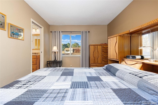 bedroom featuring connected bathroom and a textured ceiling