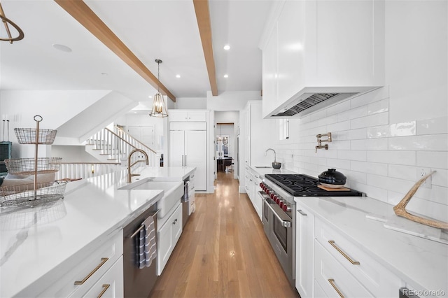 kitchen with stainless steel appliances, a sink, tasteful backsplash, beam ceiling, and light wood-type flooring