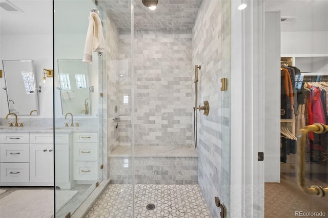 full bathroom featuring a stall shower, vanity, a spacious closet, and tile patterned floors