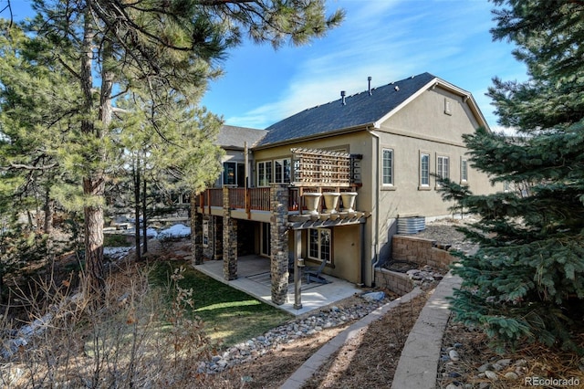 back of property with a deck and a patio