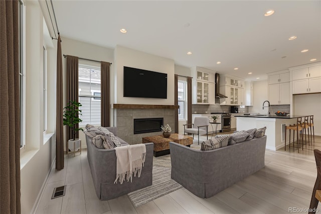 living room featuring light hardwood / wood-style floors, sink, and a fireplace