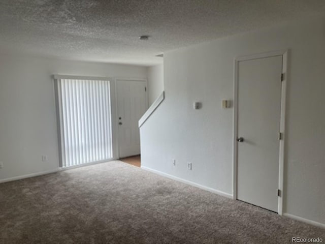 carpeted spare room featuring a textured ceiling