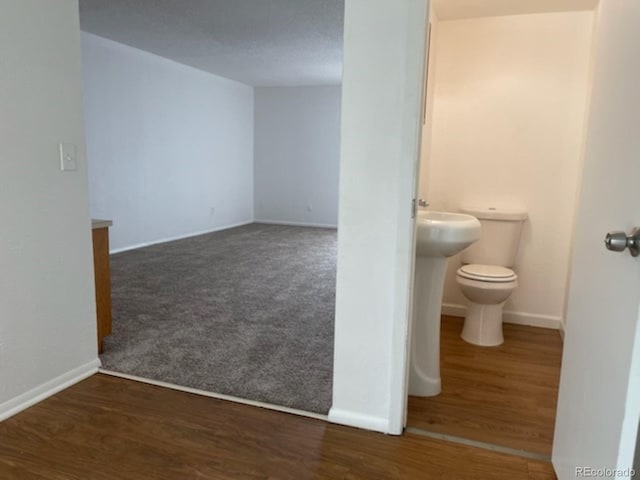 bathroom featuring wood-type flooring, a textured ceiling, and toilet