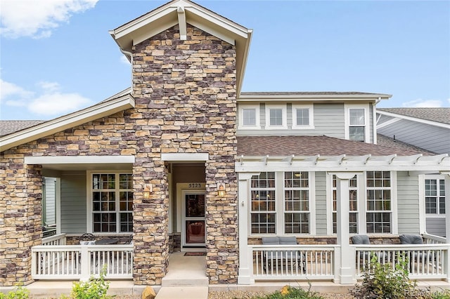5723 S Union Ct, Littleton, CO 80127 - view of front facade featuring stone siding, roof with shingles, and a porch