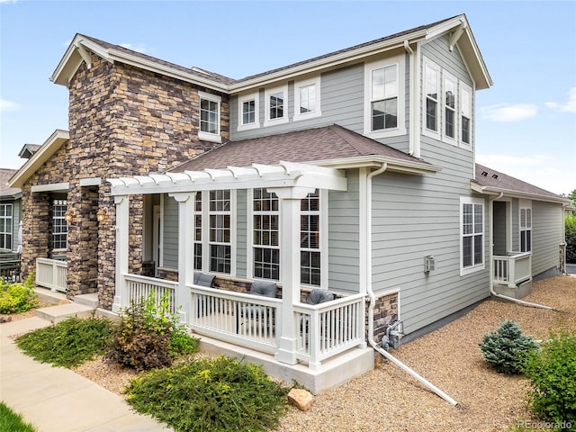 5723 S Union Ct, Littleton, CO 80127 - view of side of home featuring stone siding, roof with shingles, and a porch