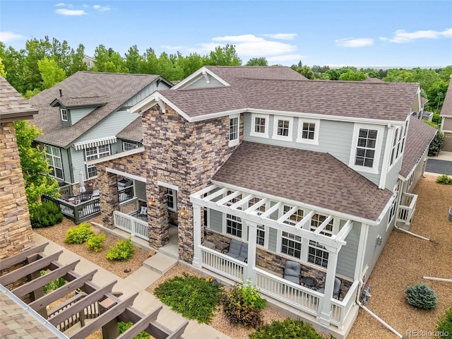 5723 S Union Ct, Littleton, CO 80127 - view of front of property featuring a shingled roof, stone siding, a pergola, and a deck