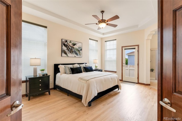 5723 S Union Ct, Littleton, CO 80127 - bedroom featuring a raised ceiling, light wood-style flooring, access to exterior, and a ceiling fan