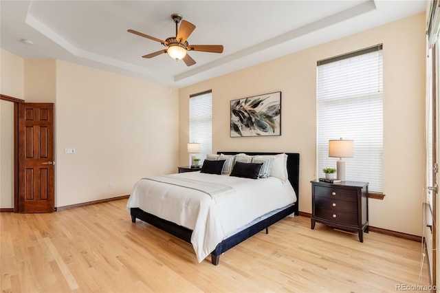 5723 S Union Ct, Littleton, CO 80127 - bedroom with a raised ceiling, light wood-style floors, and a ceiling fan