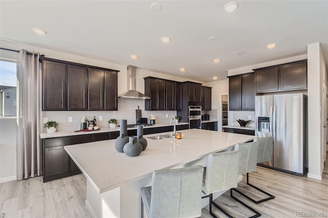 14147 Bunny Hop Ln, Parker, CO 80134 - kitchen with stainless steel appliances, wall chimney exhaust hood, a sink, dark brown cabinets, and recessed lighting