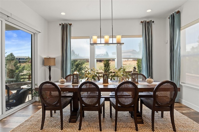 dining space featuring recessed lighting, baseboards, wood finished floors, and a notable chandelier