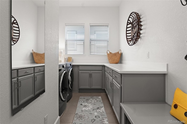 washroom with cabinet space, tile patterned floors, and washer and dryer