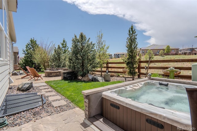view of yard featuring fence, a patio, a hot tub, and an outdoor fire pit