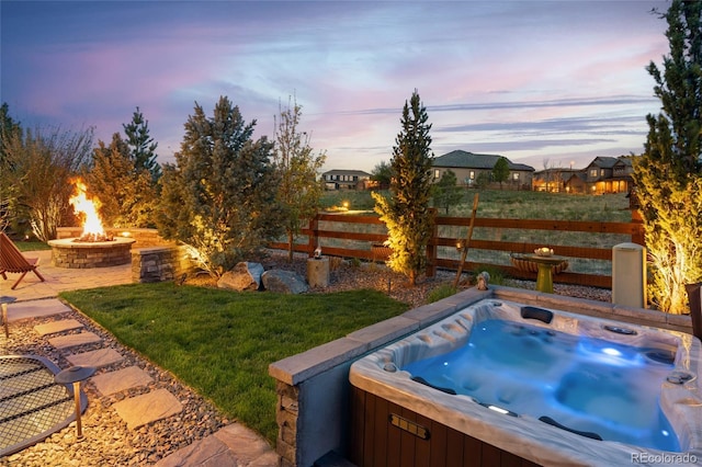 view of yard featuring fence, a hot tub, and an outdoor fire pit