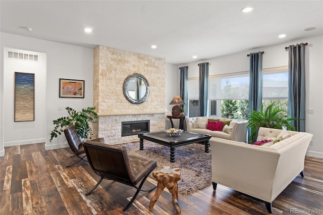 living room featuring baseboards, dark wood-type flooring, and a fireplace