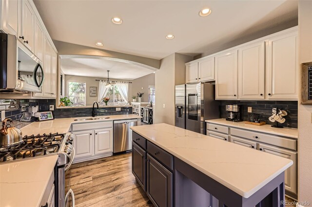 10694 Cedarcrest Cir, Highlands Ranch, CO 80130 - kitchen featuring stainless steel appliances, a sink, arched walkways, white cabinets, and recessed lighting