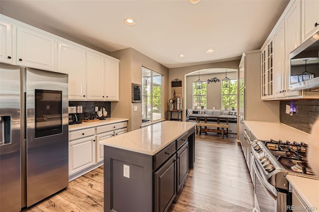 10694 Cedarcrest Cir, Highlands Ranch, CO 80130 - kitchen with appliances with stainless steel finishes, light wood-type flooring, recessed lighting, white cabinetry, and decorative backsplash