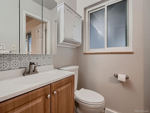 7112 S Platte Canyon Dr, Littleton, CO 80128 - bathroom with toilet, vanity, and decorative backsplash