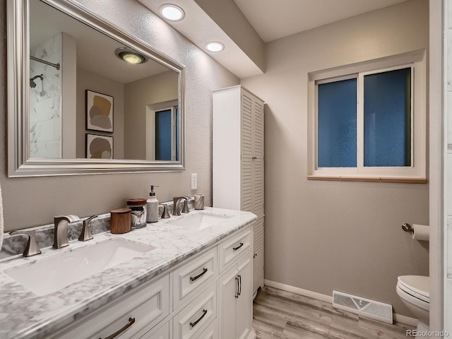 7112 S Platte Canyon Dr, Littleton, CO 80128 - full bath featuring toilet, double vanity, wood finished floors, baseboards, and a shower