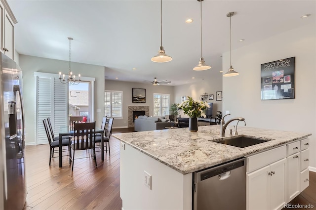 kitchen with appliances with stainless steel finishes, an island with sink, white cabinetry, and sink