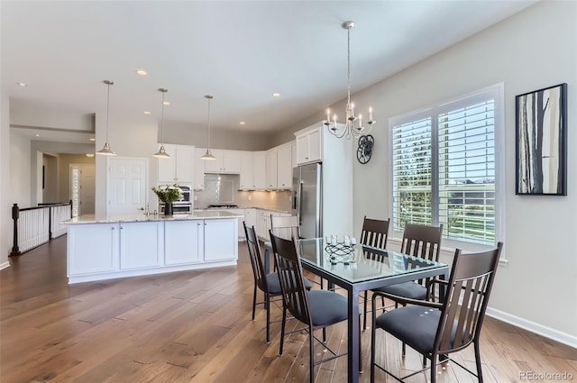 dining area featuring a notable chandelier and light wood-type flooring