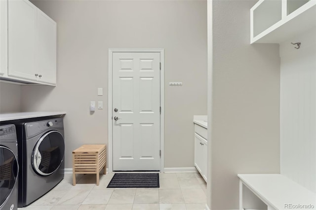 washroom featuring cabinets, light tile patterned floors, and washer and dryer