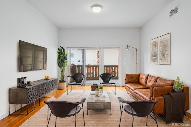 living area featuring visible vents and wood finished floors