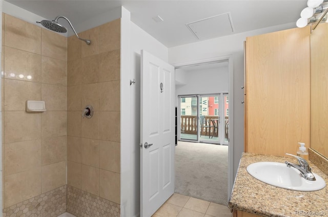 full bathroom with tile patterned floors, tiled shower, and vanity