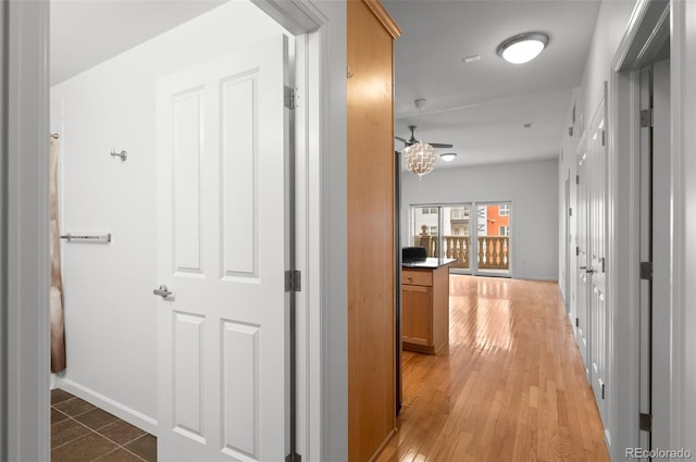 hall with light wood-type flooring and baseboards