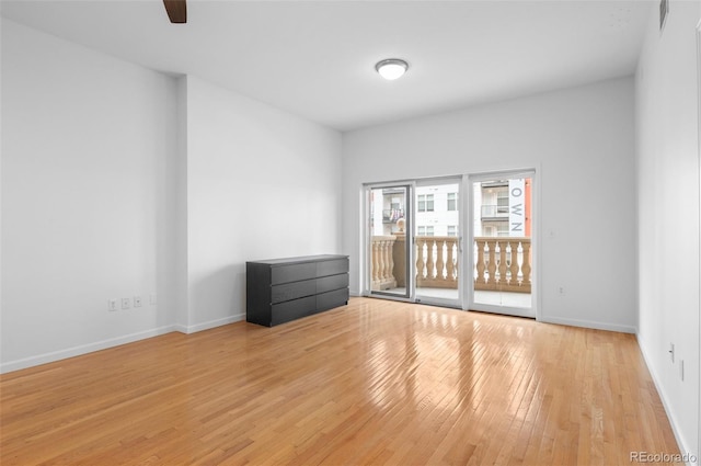 unfurnished room with baseboards and light wood-style flooring