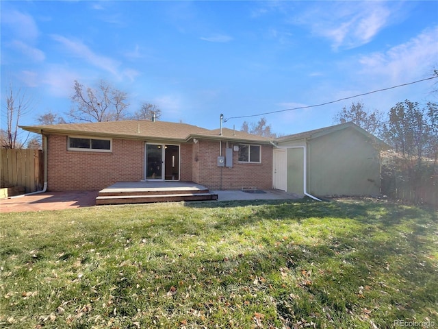 rear view of property featuring a lawn and a deck