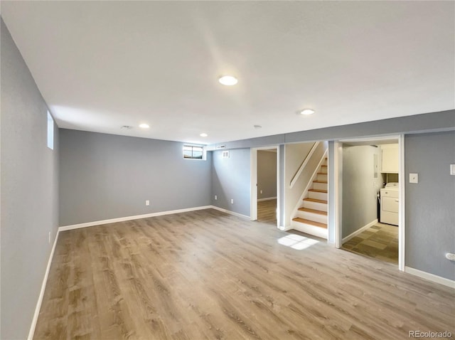 basement with light hardwood / wood-style flooring and washer / dryer