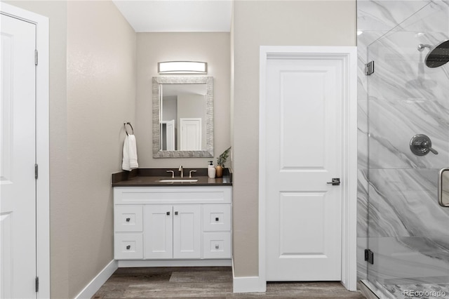 bathroom with wood-type flooring, an enclosed shower, and vanity