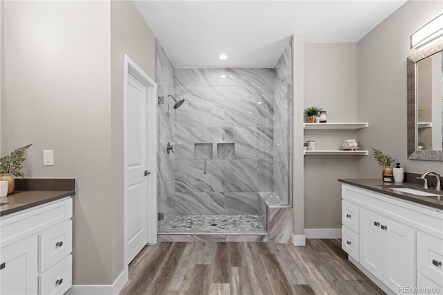 bathroom featuring hardwood / wood-style flooring, vanity, and a shower with shower door