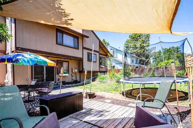 3688 S Cathay Cir, Aurora, CO 80013 - wooden terrace with a trampoline, a fenced backyard, and outdoor dining area