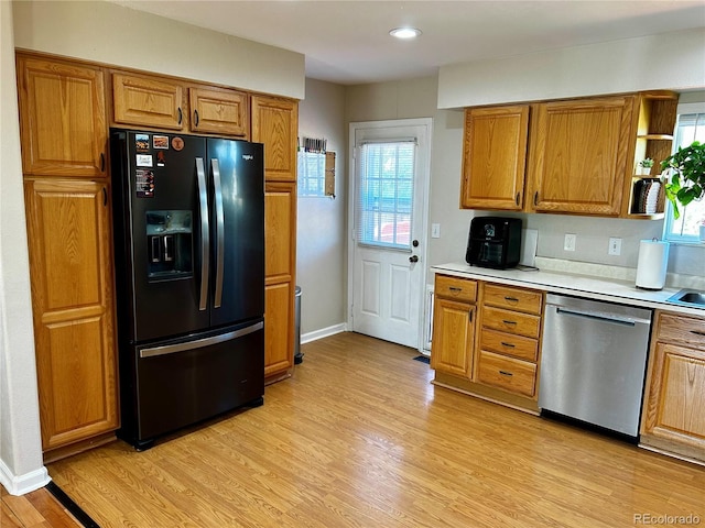 4303 S Yank St, Morrison, CO 80465 - kitchen featuring black fridge with ice dispenser, stainless steel dishwasher, brown cabinetry, light countertops, and light wood-style flooring