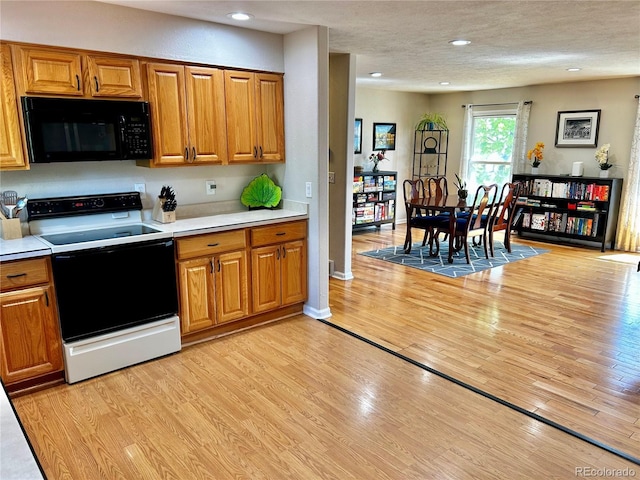 4303 S Yank St, Morrison, CO 80465 - kitchen with black microwave, electric range oven, brown cabinets, recessed lighting, and a textured ceiling