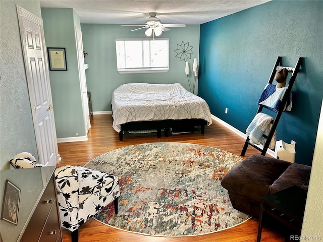 4303 S Yank St, Morrison, CO 80465 - bedroom featuring wood finished floors, a textured wall, baseboards, and ceiling fan