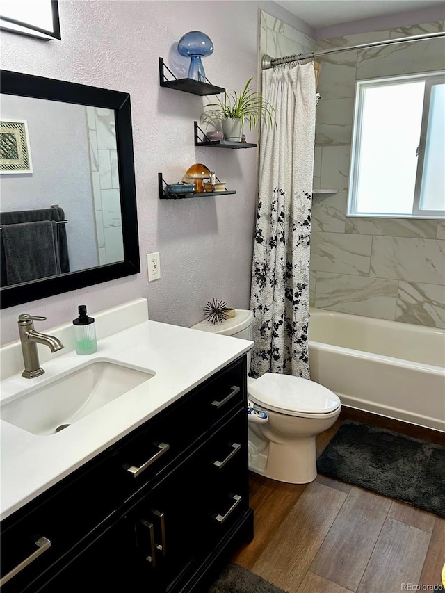 4303 S Yank St, Morrison, CO 80465 - bathroom featuring toilet, vanity, shower / bath combo, wood finished floors, and a textured wall