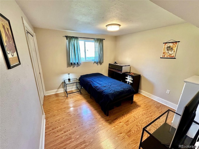 4303 S Yank St, Morrison, CO 80465 - bedroom with light wood-type flooring, baseboards, and a textured ceiling