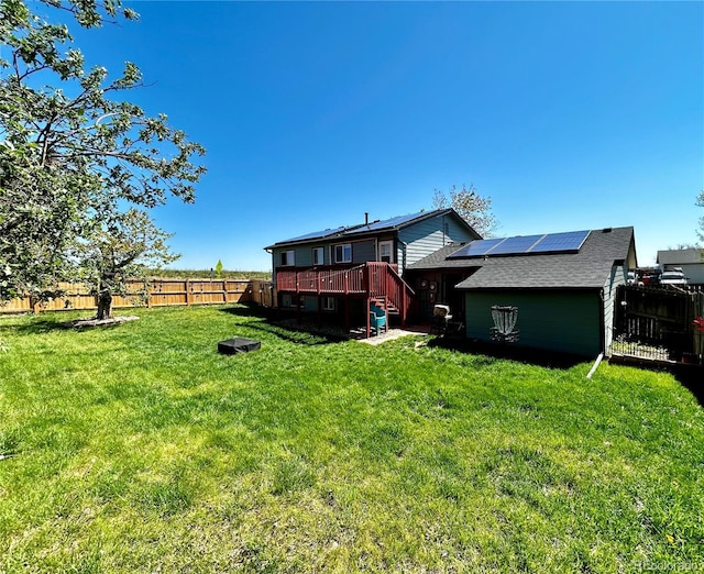 4303 S Yank St, Morrison, CO 80465 - rear view of house with roof mounted solar panels, a wooden deck, and roof with shingles