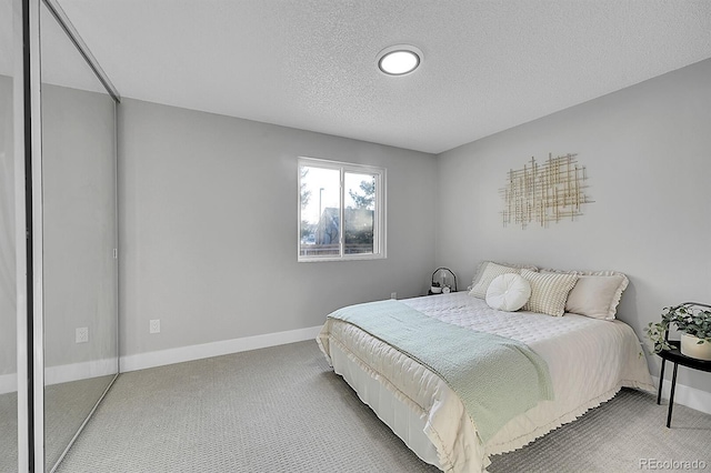 bedroom with a textured ceiling and carpet