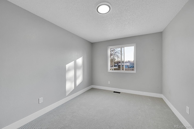 unfurnished room featuring carpet floors and a textured ceiling