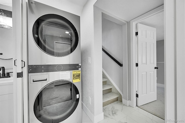 clothes washing area featuring stacked washer and dryer