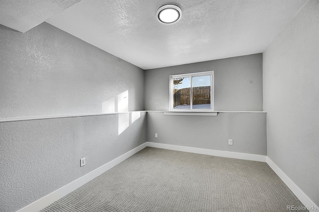 spare room with carpet flooring and a textured ceiling