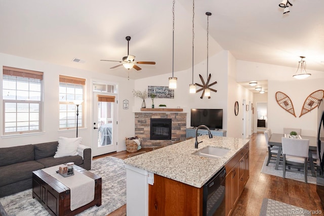 kitchen with a kitchen island with sink, wood-type flooring, vaulted ceiling, dishwasher, and sink