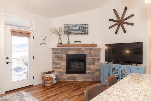 living room featuring ceiling fan, a stone fireplace, lofted ceiling, and hardwood / wood-style floors