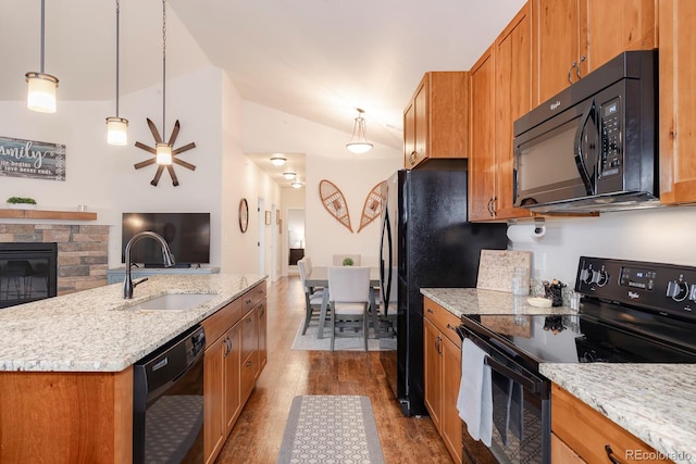 kitchen with lofted ceiling, hanging light fixtures, hardwood / wood-style floors, black appliances, and sink